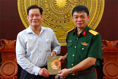 Đồng chí Lường Văn Khoa - nguyên Phó Hiệu trưởng Trường Quân sự Quân khu 7 tặng sách cho nhà trường