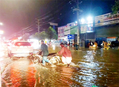 Lực lượng vũ trang thành phố Bến Cát hỗ trợ người dân lưu thông an toàn trong mưa